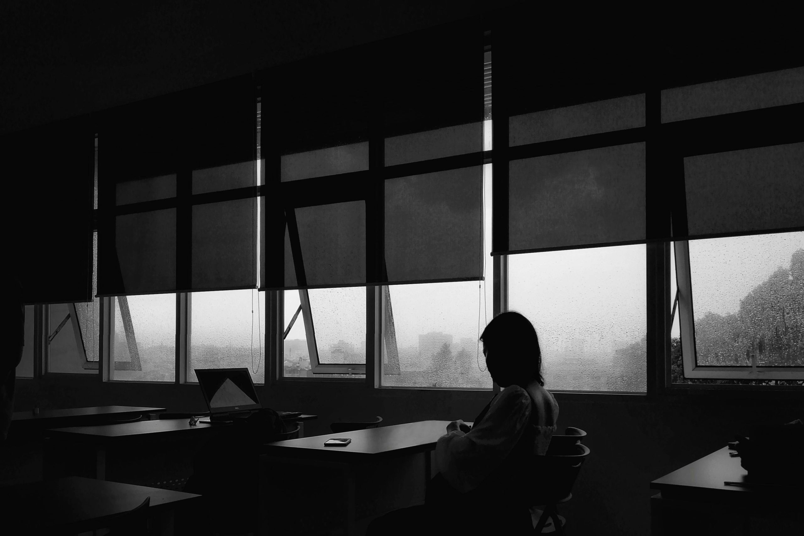 Grayscale Photo of Person Sitting on Chair